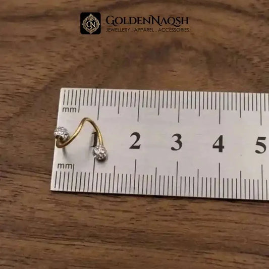 A small gold hoop earring with two clear gemstones, shown next to a white ruler marked in millimeters on a wooden surface, with the GoldenNaqsh brand logo at the top.