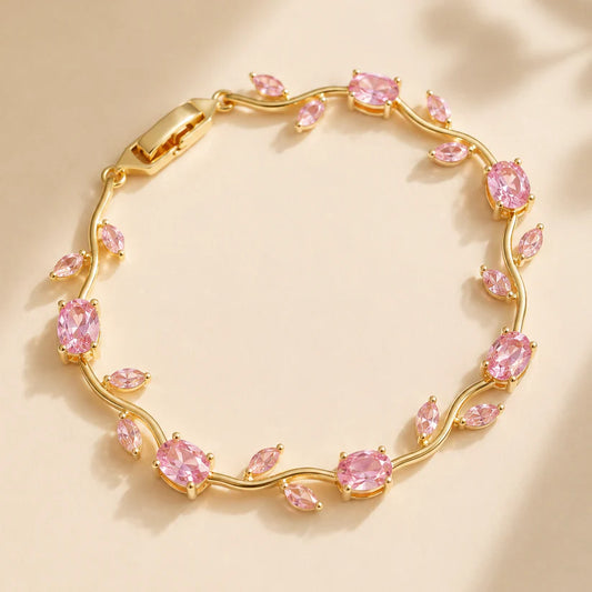 Gold bracelet with pink gemstones on a beige background
