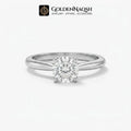 A classic solitaire engagement ring featuring a round brilliant-cut diamond set in a polished silver-colored metal band, presented on a clean white background with the GoldenNaqsh brand logo at the top.