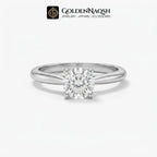 A classic solitaire engagement ring featuring a round brilliant-cut diamond set in a polished silver-colored metal band, presented on a clean white background with the GoldenNaqsh brand logo at the top.