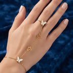 Close-up of a woman's hand wearing the Golden Naqsh 18K gold plated butterfly hand chain bracelet connected to an adjustable ring