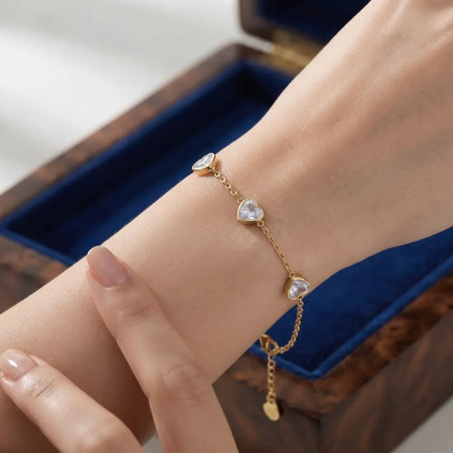 Close-up shot of a woman wearing the Golden Naqsh 18K gold plated 3 crystal heart chain bracelet featuring sparkling heart-shaped cubic zirconia stations