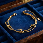 Close-up shot of a woman wearing the Golden Naqsh 18K gold plated 3 layer beaded chain bracelet layered on her wrist