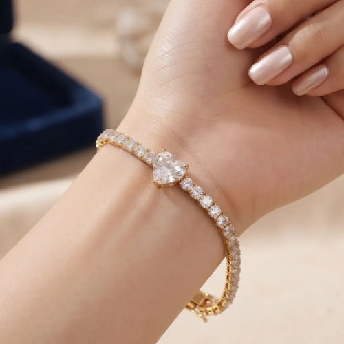 Close-up shot of a woman wearing the Golden Naqsh heart solitaire diamond tennis bracelet on her wrist