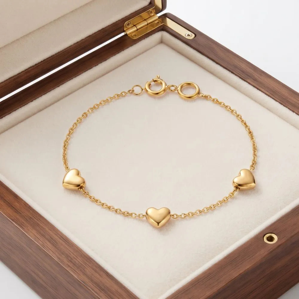 Close-up view of a woman wearing the Golden Naqsh 18K gold plated 3 heart chain bracelet on her wrist for a chic minimalist look