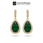 A pair of gold teardrop-shaped drop earrings featuring deep green teardrop gemstones surrounded by small clear stones, shown on a white background with the GoldenNaqsh brand logo at the top.