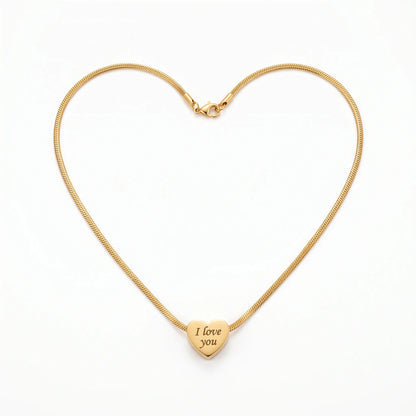 Gold necklace forming a heart shape with a heart-shaped pendant engraved 'I love you' on a white background.