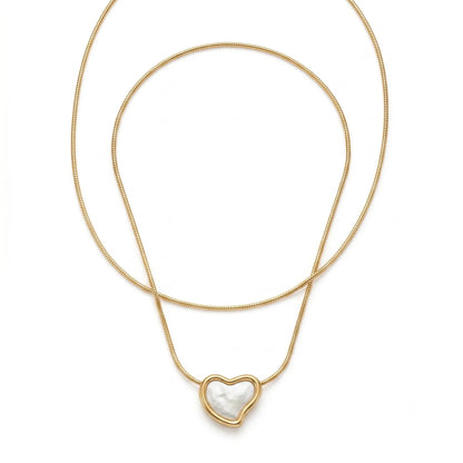 Gold necklace with a heart-shaped pendant on a white background