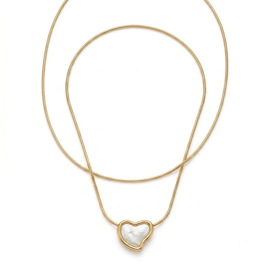 Gold necklace with a heart-shaped pendant on a white background