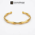 A gold-toned bamboo-style cuff bracelet displayed on a clean white background, with the GoldenNaqsh brand logo visible at the top.