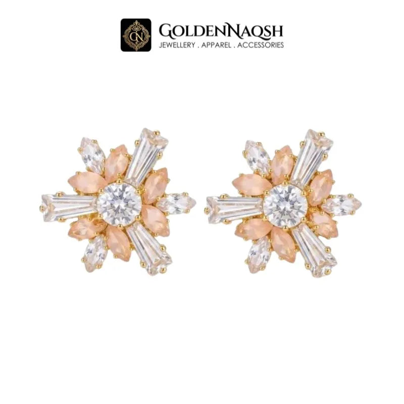 A pair of gold and peach flower-shaped stud earrings with clear marquise and round-cut rhinestones, displayed on a white background with the GoldenNaqsh brand logo at the top.