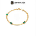 A gold snake chain bracelet with four rectangular green emerald-cut stones, displayed on a clean white background with the GoldenNaqsh brand logo at the top.