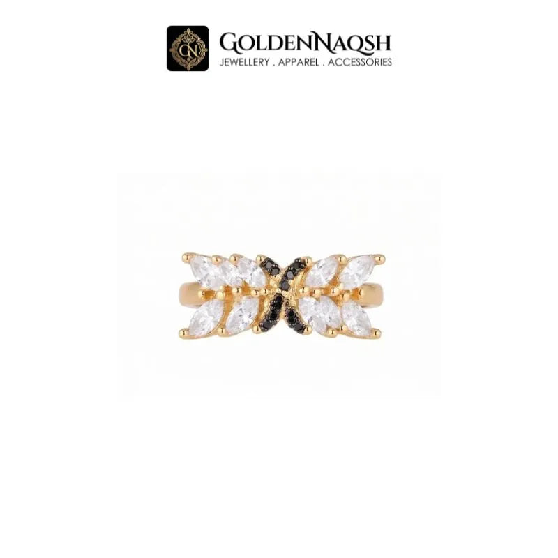 A gold butterfly ring with clear marquise-cut stones on a white background, featuring a black center accent. The brand logo 'GOLDENNAQSH' is visible at the top.