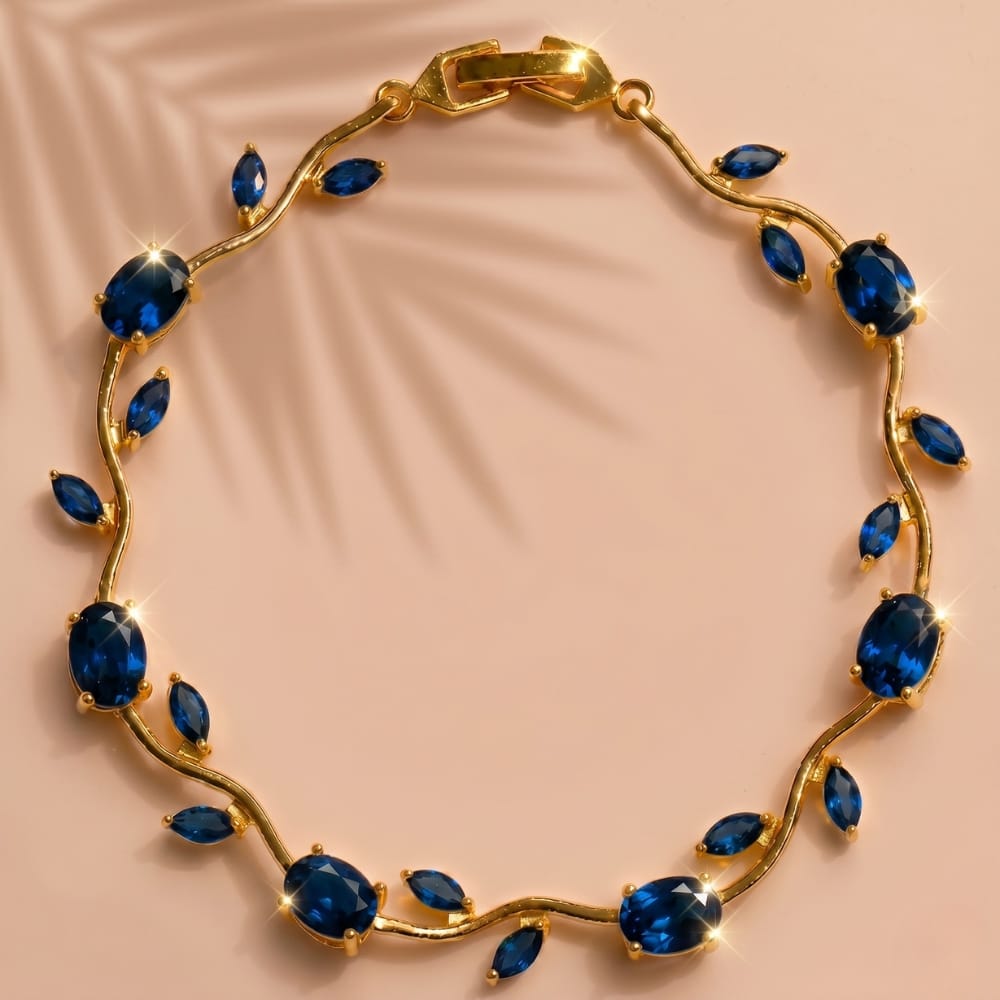 Gold bracelet with blue gemstones on a beige background