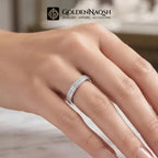 A close-up of a hand wearing a silver-toned eternity ring set with small clear stones. The GoldenNaqsh brand logo is visible at the top of the image.