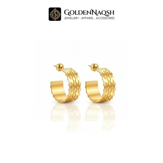 A pair of gold hoop earrings with a textured, wavy outer surface and a smooth inner band, displayed on a clean white background with a reflection below. The brand logo 'GOLDENNAQSH' is visible at the top.