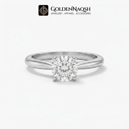 A classic solitaire engagement ring featuring a round brilliant-cut diamond set in a polished silver-colored metal band, presented on a clean white background with the GoldenNaqsh brand logo at the top.