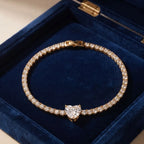 Top-down view of the Golden Naqsh 18K gold plated heart solitaire tennis bracelet displayed on dark blue lining